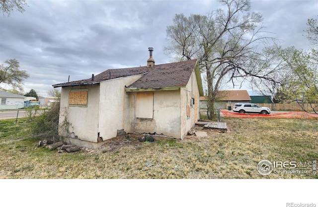 701 Phelps St, Sterling, CO 80751 - view of home's exterior with stucco siding and a shingled roof