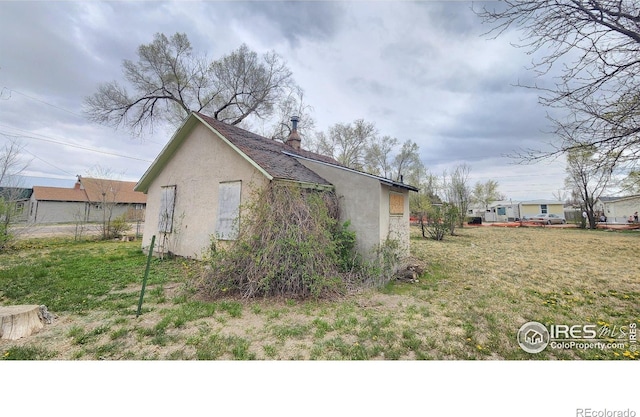 701 Phelps St, Sterling, CO 80751 - view of home's exterior featuring stucco siding and a lawn