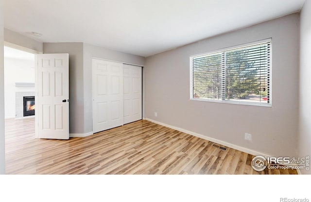 6110 Habitat Dr Unit 2, Boulder, CO 80301 - unfurnished bedroom featuring light wood-style flooring, baseboards, a closet, and a fireplace