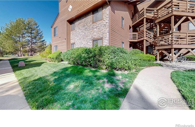6110 Habitat Dr Unit 2, Boulder, CO 80301 - view of property exterior featuring stone siding, a yard, and a deck