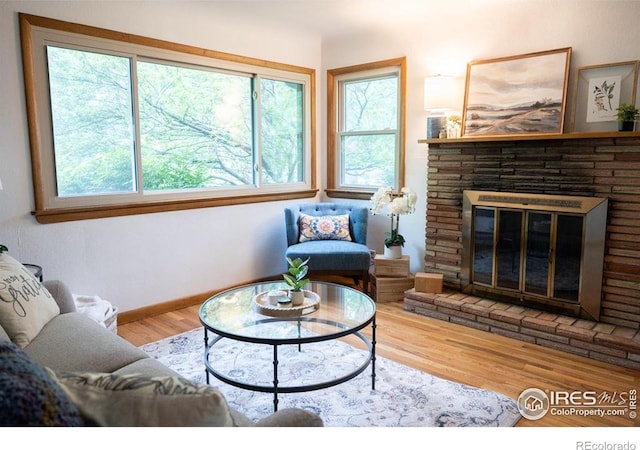 508 W 11th St, Loveland, CO 80537 - living area with healthy amount of natural light, wood finished floors, a glass covered fireplace, and baseboards
