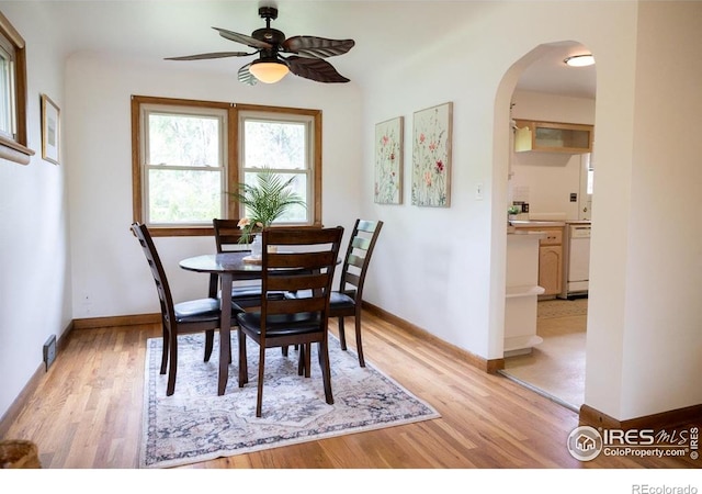 508 W 11th St, Loveland, CO 80537 - dining space featuring arched walkways, ceiling fan, light wood-style flooring, and baseboards
