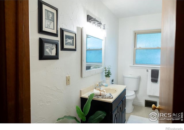 508 W 11th St, Loveland, CO 80537 - bathroom featuring toilet, vanity, and baseboards
