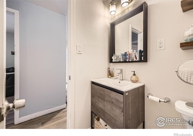 3245 W Walsh Pl, Denver, CO 80219 - bathroom featuring wood finished floors, vanity, and toilet