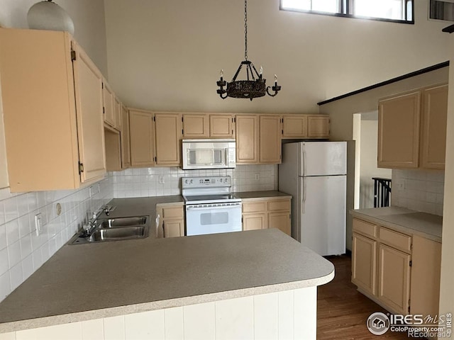 1943 Meadow Dr Unit B2, Longmont, CO 80501 - kitchen featuring white appliances, a sink, decorative backsplash, a towering ceiling, and a chandelier