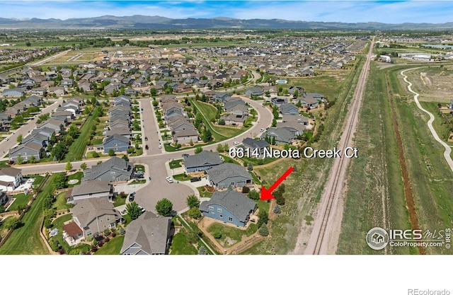 6614 Neota Creek Ct, Timnath, CO 80547 - aerial overview of property's location featuring nearby suburban area and a mountain backdrop