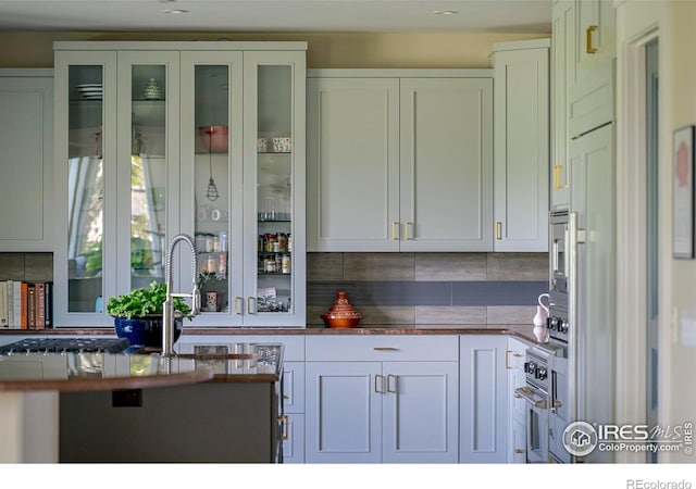 7205 Rustic Trl, Boulder, CO 80301 - kitchen featuring tasteful backsplash, white cabinetry, and glass insert cabinets