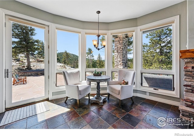 290 Skyhill Dr, Evergreen, CO 80439 - dining area with stone tile floors, a chandelier, and plenty of natural light