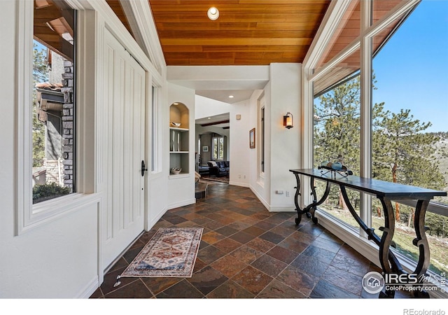 290 Skyhill Dr, Evergreen, CO 80439 - foyer featuring stone tile floors, baseboards, plenty of natural light, wooden ceiling, and arched walkways