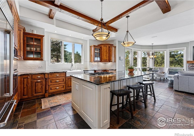 290 Skyhill Dr, Evergreen, CO 80439 - kitchen with stone tile flooring, a sink, brown cabinets, plenty of natural light, and beam ceiling