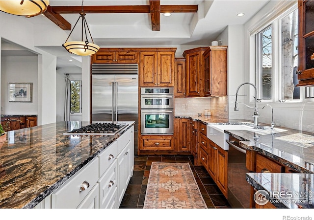 290 Skyhill Dr, Evergreen, CO 80439 - kitchen with a sink, healthy amount of natural light, stainless steel appliances, brown cabinetry, and beam ceiling