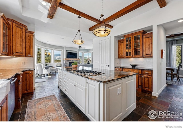 290 Skyhill Dr, Evergreen, CO 80439 - kitchen with appliances with stainless steel finishes, stone tile flooring, open floor plan, brown cabinetry, and glass insert cabinets