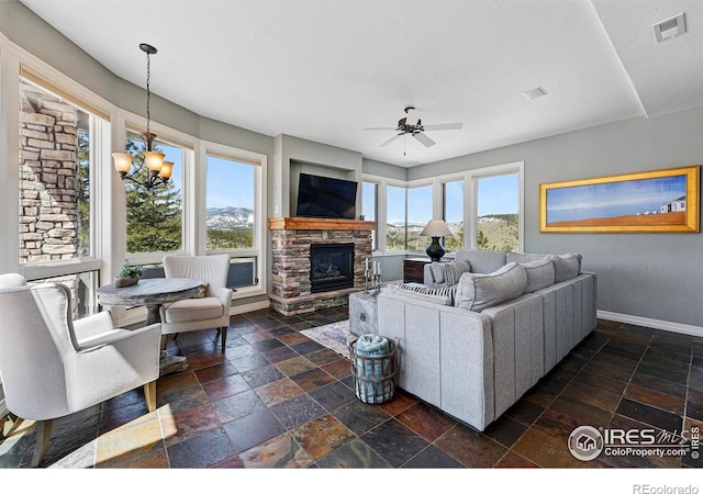 290 Skyhill Dr, Evergreen, CO 80439 - living room with stone tile floors, baseboards, a stone fireplace, and ceiling fan