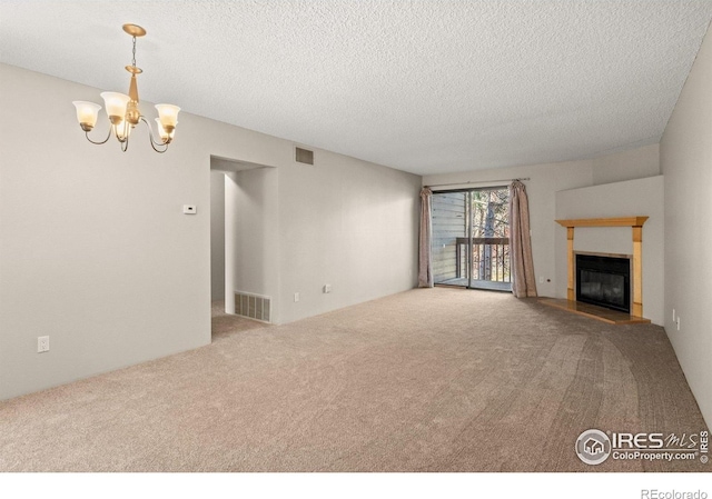 316 Wright St Unit 203, Lakewood, CO 80228 - unfurnished living room with carpet flooring, a chandelier, a glass covered fireplace, and a textured ceiling