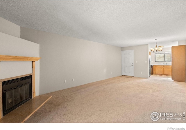 316 Wright St Unit 203, Lakewood, CO 80228 - unfurnished living room featuring a chandelier, carpet, a fireplace, a textured ceiling, and a sink