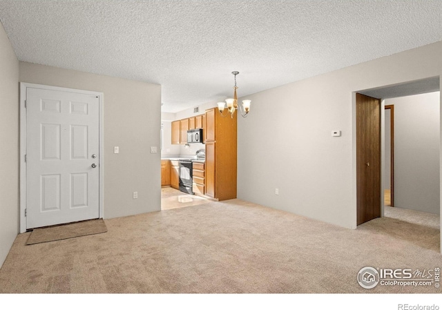 316 Wright St Unit 203, Lakewood, CO 80228 - unfurnished living room featuring a chandelier, light carpet, and a textured ceiling