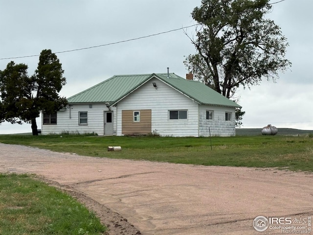 29640 County Road 38, Wray, CO 80758 - view of front of house with a front yard, a chimney, and dirt driveway