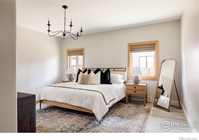 320 Elk Ln, Grand Lake, CO 80447 - bedroom with wood finished floors, a chandelier, baseboards, and a baseboard radiator