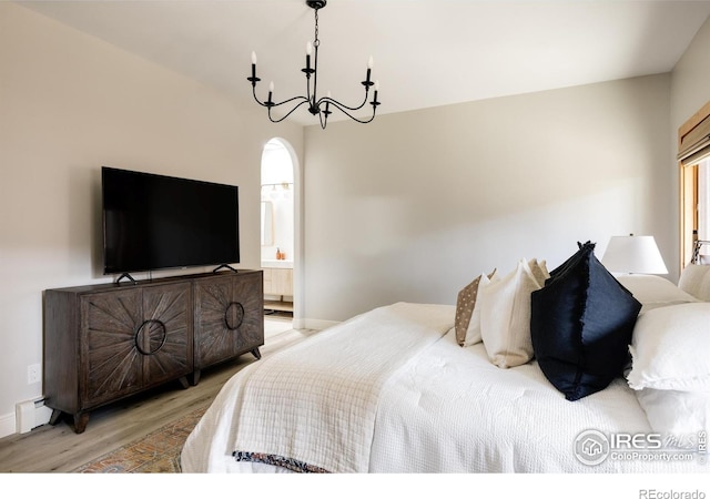 320 Elk Ln, Grand Lake, CO 80447 - bedroom with light wood-type flooring, a chandelier, a baseboard radiator, ensuite bathroom, and arched walkways