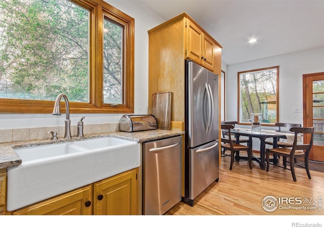 4157 19th St, Boulder, CO 80304 - kitchen featuring appliances with stainless steel finishes, a sink, light wood-type flooring, recessed lighting, and light stone countertops