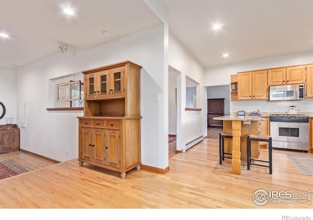 4157 19th St, Boulder, CO 80304 - kitchen with stainless steel appliances, a baseboard heating unit, a kitchen breakfast bar, light wood-type flooring, and recessed lighting