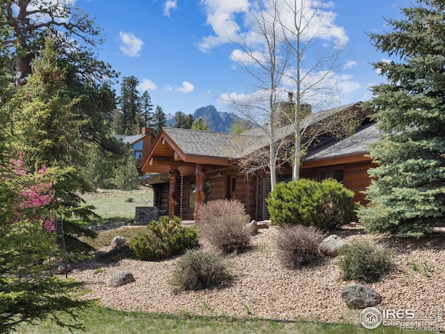 2030 Cherokee Dr, Estes Park, CO 80517 - view of front of home with a mountain view, a shingled roof, a garage, and a chimney