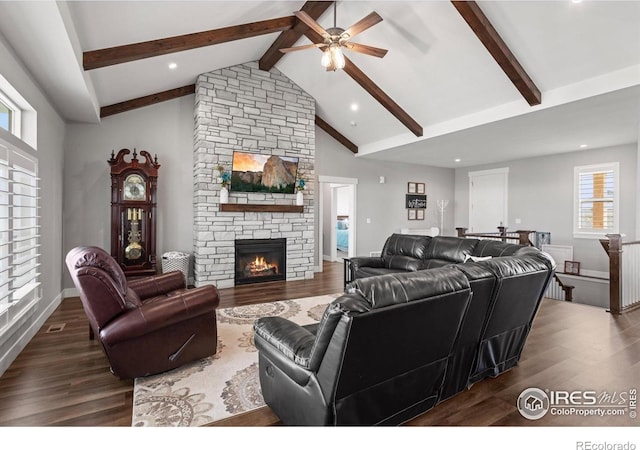 5031 Prairie Lark Ln, Severance, CO 80615 - living area featuring ceiling fan, beamed ceiling, wood finished floors, a stone fireplace, and high vaulted ceiling