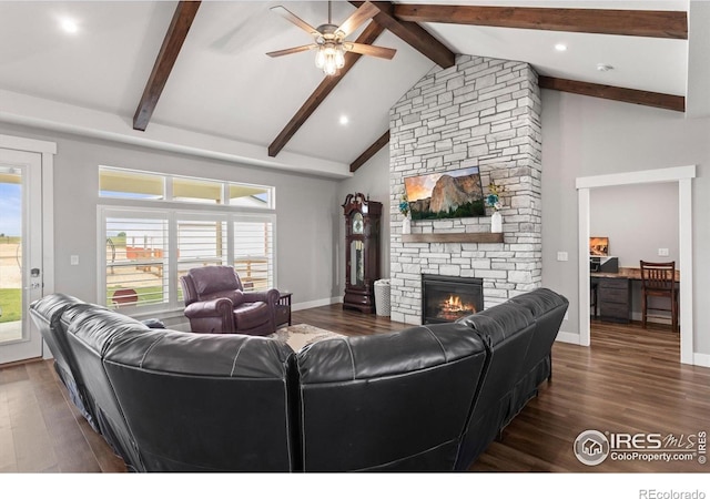 5031 Prairie Lark Ln, Severance, CO 80615 - living area featuring a fireplace, beam ceiling, a ceiling fan, dark wood-style flooring, and healthy amount of natural light