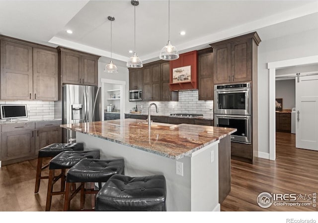 5031 Prairie Lark Ln, Severance, CO 80615 - kitchen with stainless steel appliances, a sink, light stone countertops, dark wood-style floors, and recessed lighting