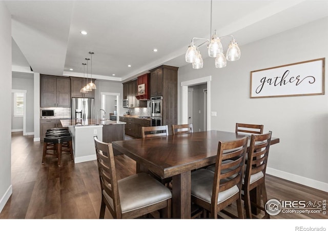 5031 Prairie Lark Ln, Severance, CO 80615 - dining space with a chandelier, dark wood-type flooring, recessed lighting, and baseboards