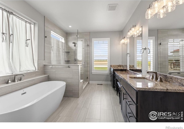5031 Prairie Lark Ln, Severance, CO 80615 - bathroom featuring a stall shower, a freestanding bath, vanity, baseboards, and a chandelier