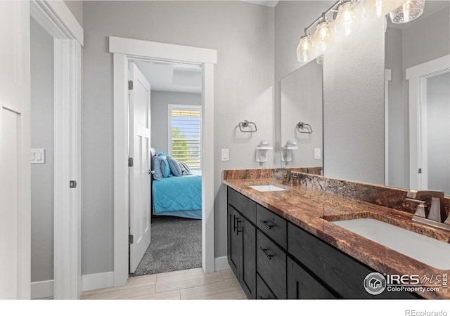 5031 Prairie Lark Ln, Severance, CO 80615 - full bath with double vanity, connected bathroom, and baseboards