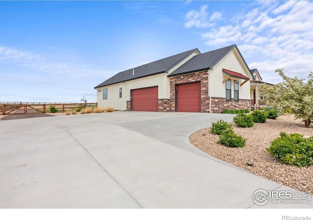 5031 Prairie Lark Ln, Severance, CO 80615 - view of home's exterior featuring board and batten siding, a garage, stone siding, and concrete driveway