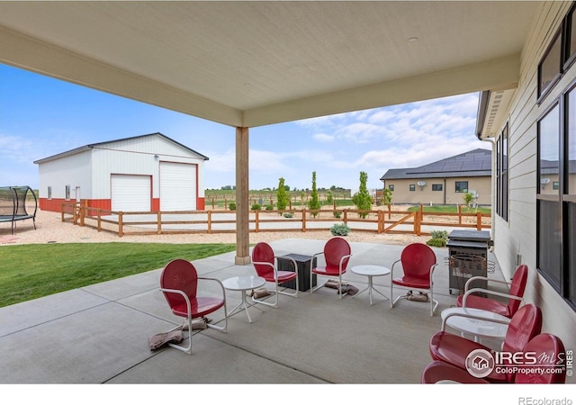 5031 Prairie Lark Ln, Severance, CO 80615 - view of patio / terrace featuring a trampoline, an outdoor structure, a garage, and grilling area
