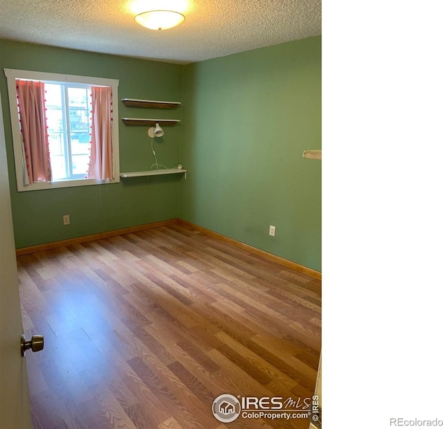 3250 Oneal Cir Unit 14, Boulder, CO 80301 - unfurnished room with wood finished floors, a textured ceiling, and baseboards