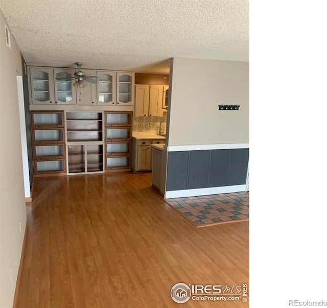 3250 Oneal Cir Unit 14, Boulder, CO 80301 - kitchen with a ceiling fan, light wood-style flooring, glass insert cabinets, a textured ceiling, and decorative backsplash