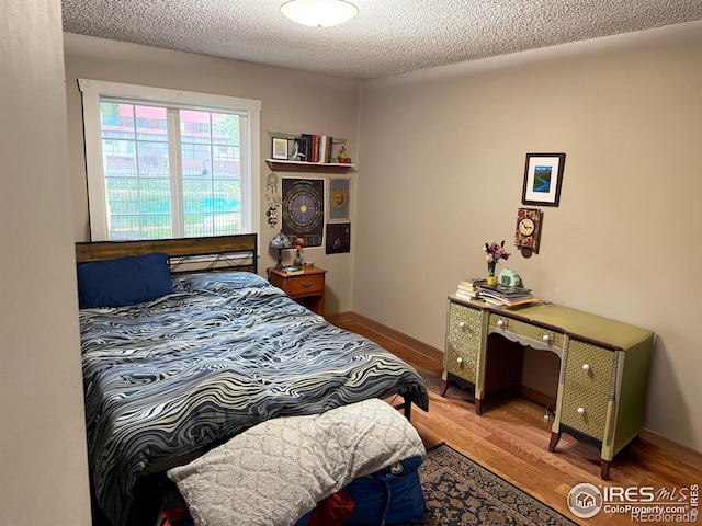 3250 Oneal Cir Unit 14, Boulder, CO 80301 - bedroom with light wood-type flooring, a textured ceiling, and baseboards