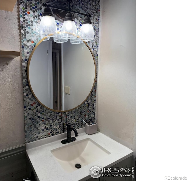 3250 Oneal Cir Unit 14, Boulder, CO 80301 - bathroom with vanity, a chandelier, decorative backsplash, and a textured wall