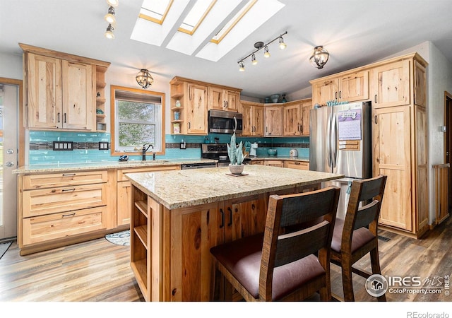 10635 County Road 24, Fort Lupton, CO 80621 - kitchen with open shelves, stainless steel appliances, a skylight, and light wood-type flooring