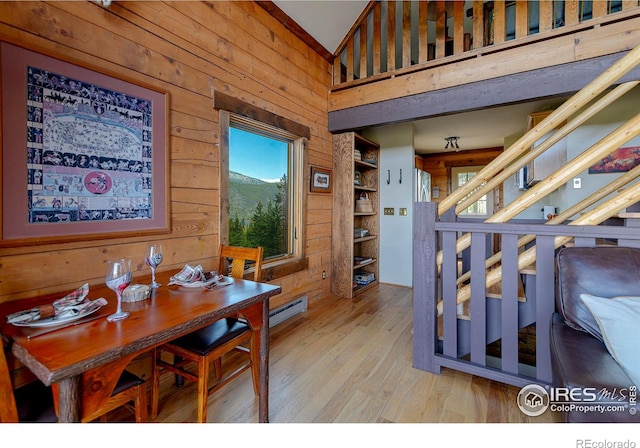 47 County Road 471, Grand Lake, CO 80447 - dining room with wood walls, hardwood / wood-style flooring, baseboard heating, and a towering ceiling