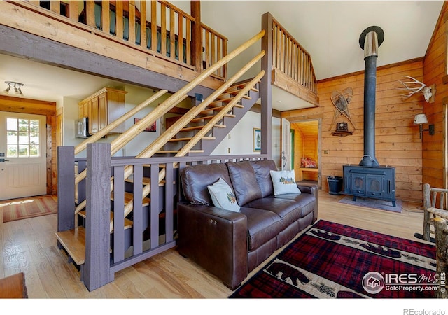47 County Road 471, Grand Lake, CO 80447 - living area featuring wooden walls, a wood stove, wood finished floors, stairs, and a high ceiling