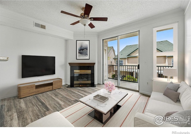 1837 Spaulding Cir, Superior, CO 80027 - living area featuring ornamental molding, wood finished floors, a ceiling fan, a textured ceiling, and a tiled fireplace