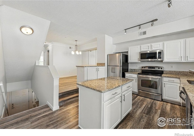 1837 Spaulding Cir, Superior, CO 80027 - kitchen with appliances with stainless steel finishes, dark wood finished floors, white cabinetry, a kitchen island, and a textured ceiling