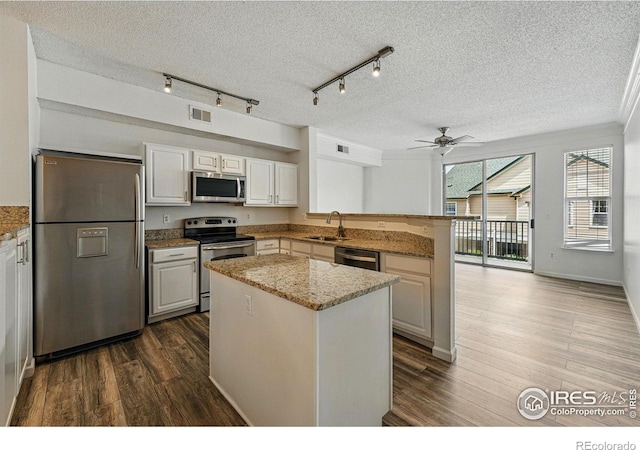 1837 Spaulding Cir, Superior, CO 80027 - kitchen with appliances with stainless steel finishes, a peninsula, a textured ceiling, ceiling fan, and a sink