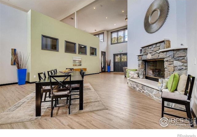 1837 Spaulding Cir, Superior, CO 80027 - dining room with wood finished floors, recessed lighting, a stone fireplace, baseboards, and a high ceiling