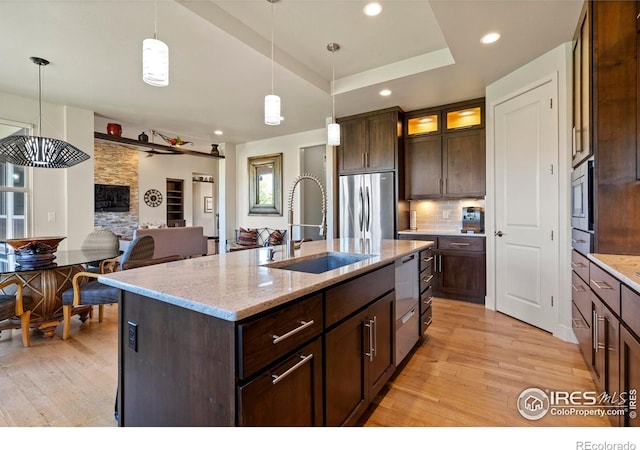 5112 Daylight Ct, Fort Collins, CO 80528 - kitchen with stainless steel appliances, a sink, light wood-type flooring, a kitchen island with sink, and recessed lighting