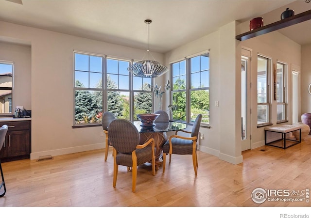 5112 Daylight Ct, Fort Collins, CO 80528 - dining space featuring a chandelier, baseboards, and light wood-style flooring