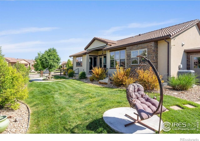 5112 Daylight Ct, Fort Collins, CO 80528 - rear view of house with stone siding, stucco siding, a yard, and a tiled roof