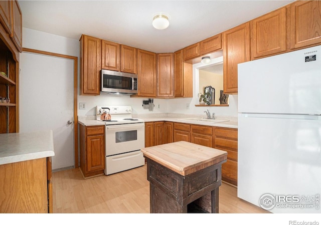 4117 Shannon Dr, Laporte, CO 80535 - kitchen with white appliances, a sink, light wood-type flooring, light countertops, and brown cabinets
