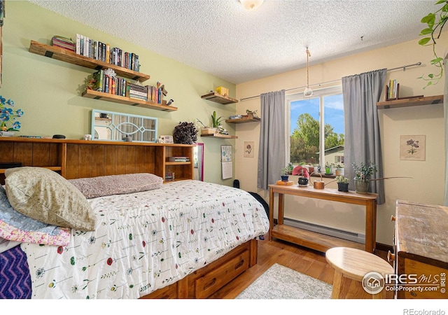 4117 Shannon Dr, Laporte, CO 80535 - bedroom with a baseboard heating unit, wood finished floors, and a textured ceiling